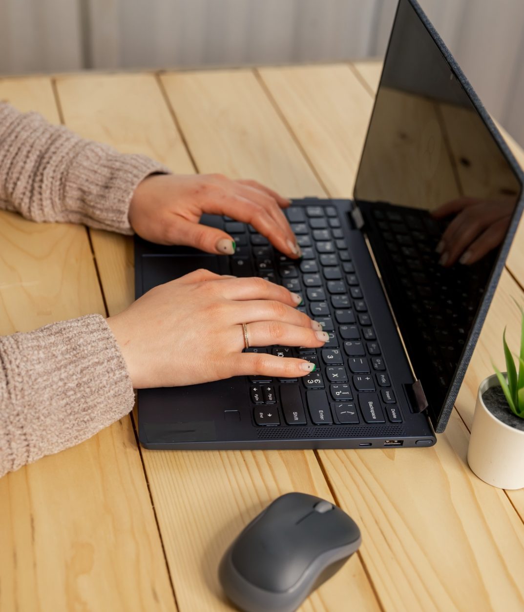 Young woman working on laptop. Female hands typing on pc keyboard.
